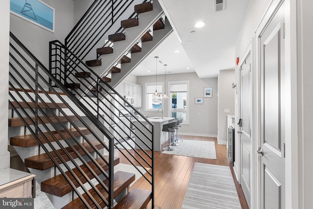 stairs with hardwood / wood-style floors and sink