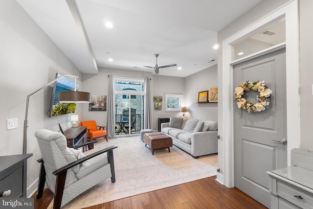 living room featuring ceiling fan and hardwood / wood-style flooring