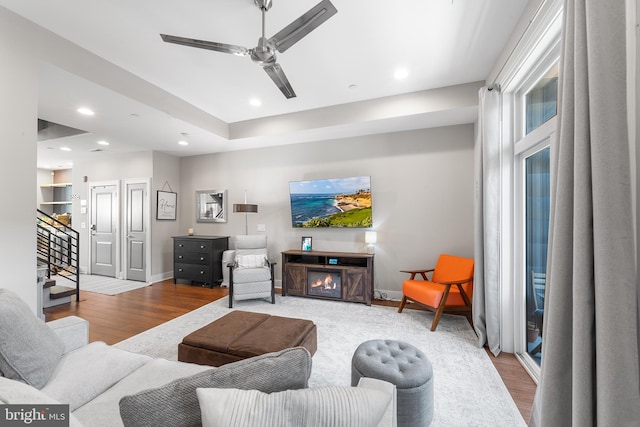 living room featuring wood-type flooring and ceiling fan