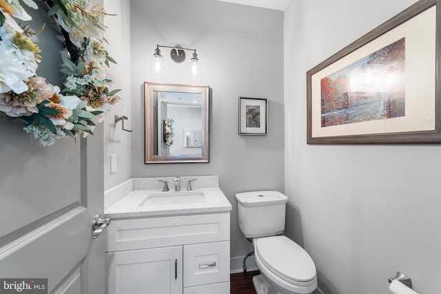 bathroom with vanity, wood-type flooring, and toilet