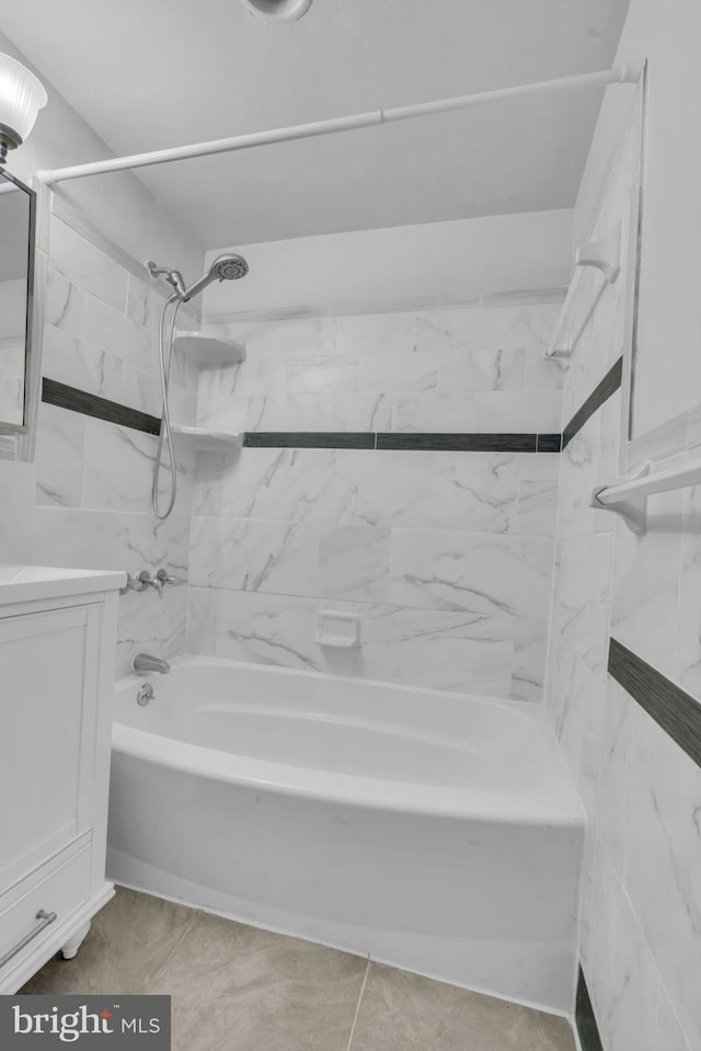 bathroom featuring tile patterned flooring, tiled shower / bath combo, and vanity