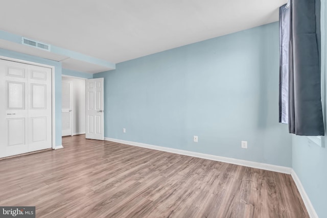 unfurnished bedroom featuring a closet and light hardwood / wood-style floors