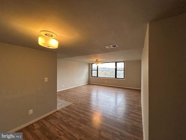 spare room with ceiling fan and dark wood-type flooring