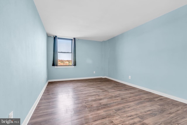 spare room featuring wood-type flooring