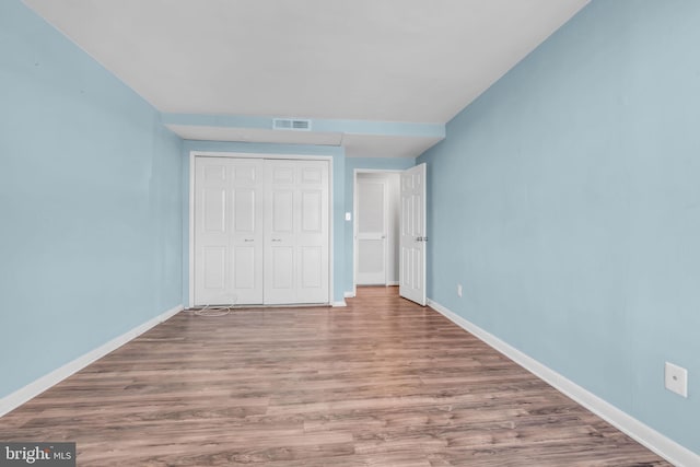 unfurnished bedroom featuring a closet and light wood-type flooring