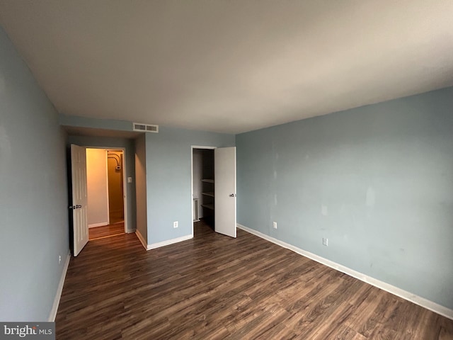 unfurnished bedroom with dark wood-type flooring and a closet