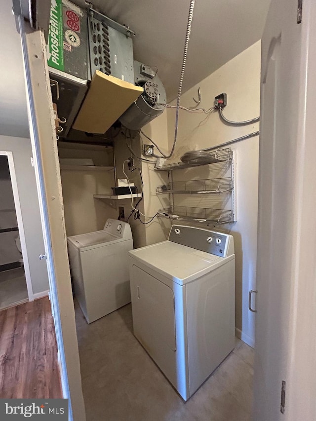 washroom featuring washing machine and clothes dryer and light hardwood / wood-style flooring