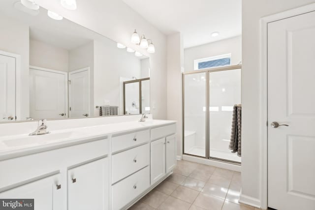 bathroom with an enclosed shower, vanity, and tile patterned flooring