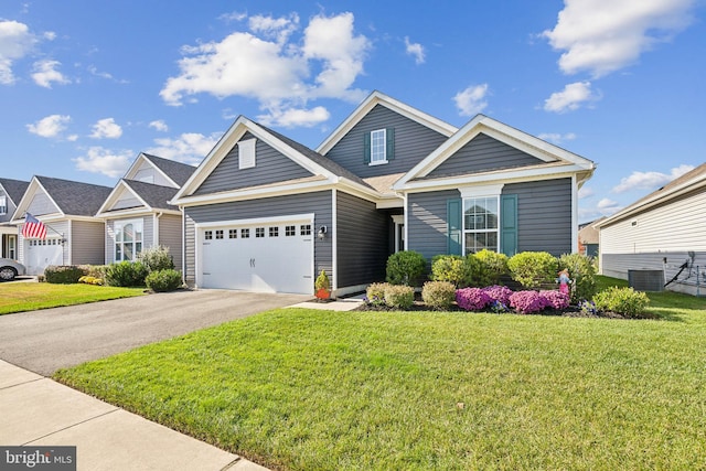 view of front of home featuring a front lawn, central air condition unit, and a garage