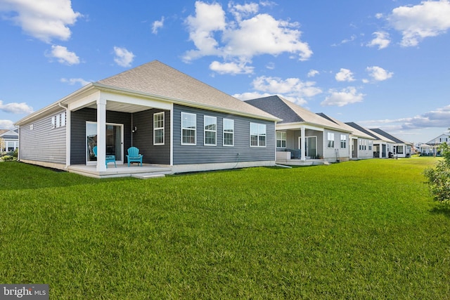 back of house featuring a lawn and a patio area