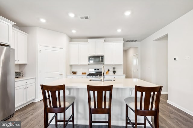 kitchen featuring white cabinets, a kitchen island with sink, and stainless steel appliances