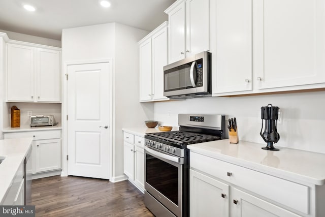 kitchen with white cabinetry, dark hardwood / wood-style floors, and stainless steel appliances