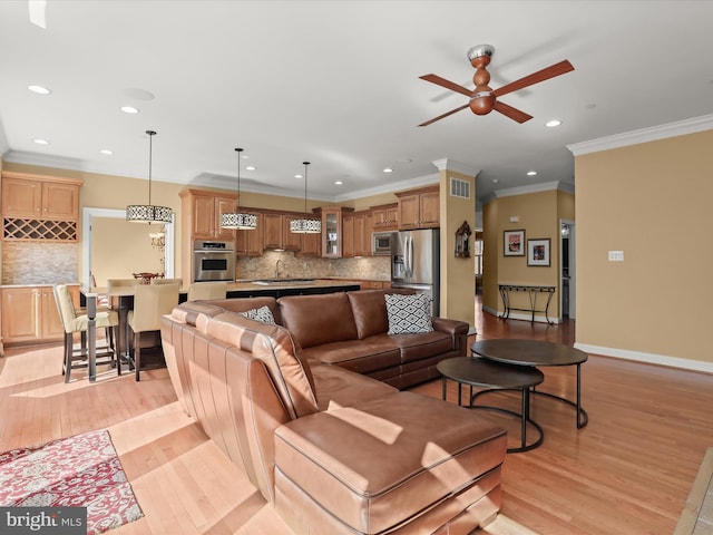 living area featuring light wood-style flooring, visible vents, ceiling fan, and baseboards