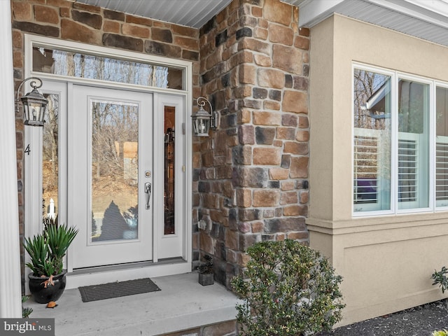 entrance to property featuring stone siding and stucco siding