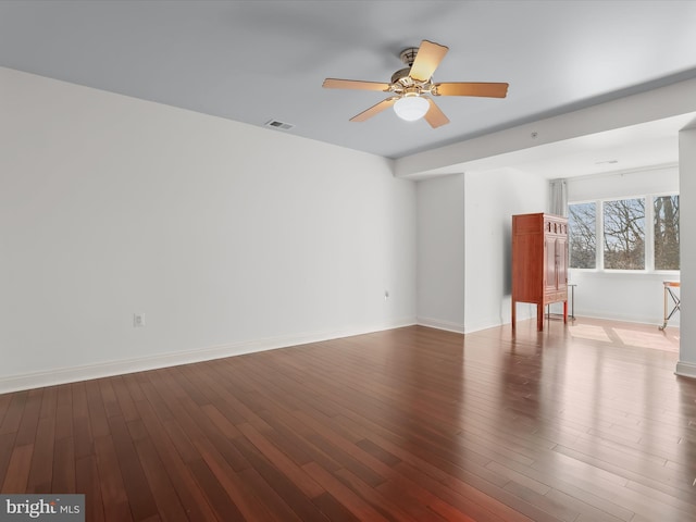 spare room featuring visible vents, baseboards, ceiling fan, and wood finished floors