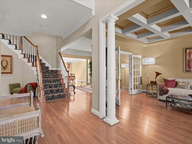 foyer entrance with ornate columns, wood-type flooring, stairs, and coffered ceiling