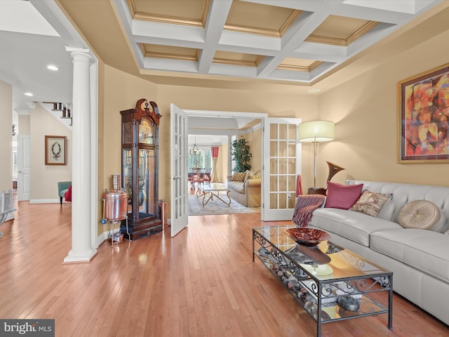 living room featuring coffered ceiling, hardwood / wood-style floors, french doors, ornate columns, and beam ceiling