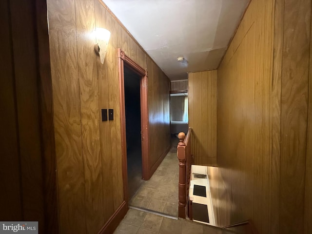 hallway featuring wood walls