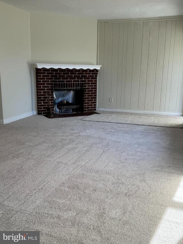 unfurnished living room with a brick fireplace and carpet floors