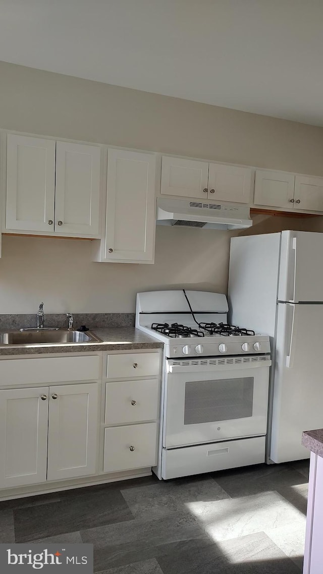 kitchen featuring white appliances, white cabinetry, and sink