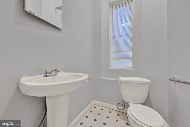 1311 N Luzerne Ave, Baltimore, MD 21213 - bathroom featuring toilet, plenty of natural light, a sink, and baseboards