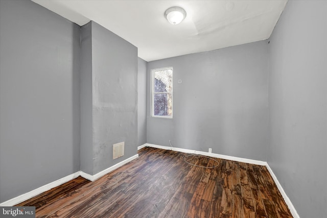 spare room with dark hardwood / wood-style flooring