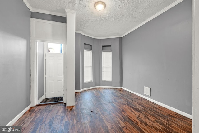 foyer entrance featuring ornamental molding, a textured ceiling, and dark hardwood / wood-style flooring