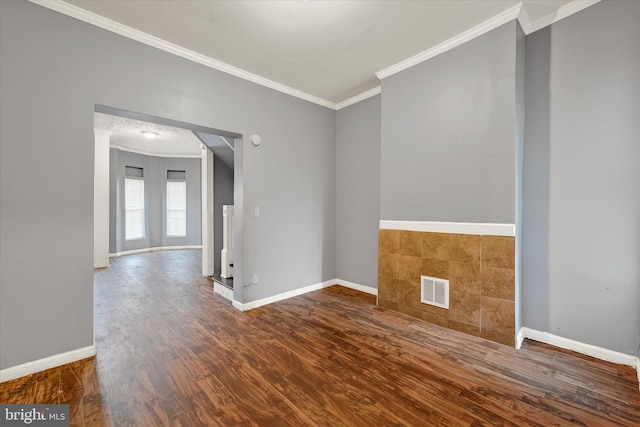 empty room featuring ornamental molding and dark wood-type flooring