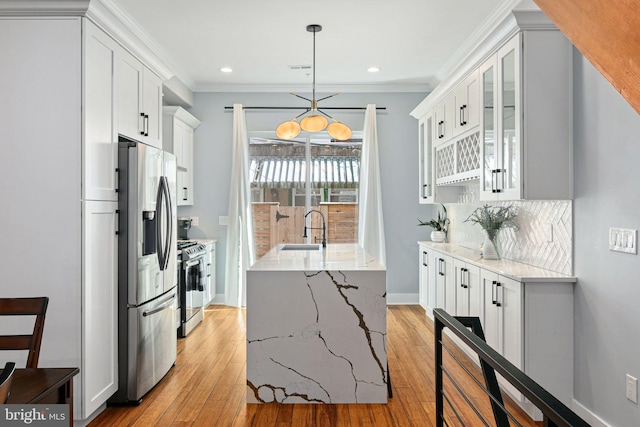 kitchen featuring white cabinets, stainless steel appliances, hanging light fixtures, and light stone counters