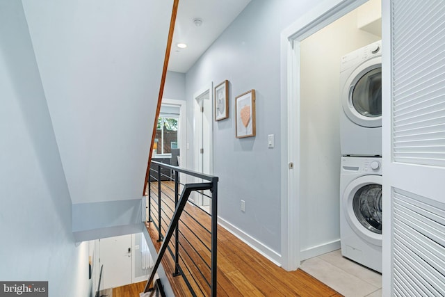 laundry area featuring light hardwood / wood-style floors and stacked washing maching and dryer