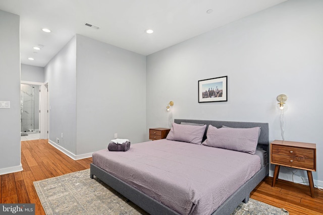 bedroom featuring connected bathroom and hardwood / wood-style floors