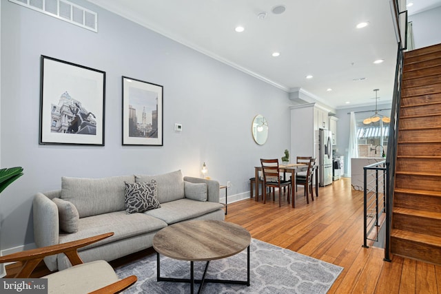 living room featuring ornamental molding, sink, and light wood-type flooring