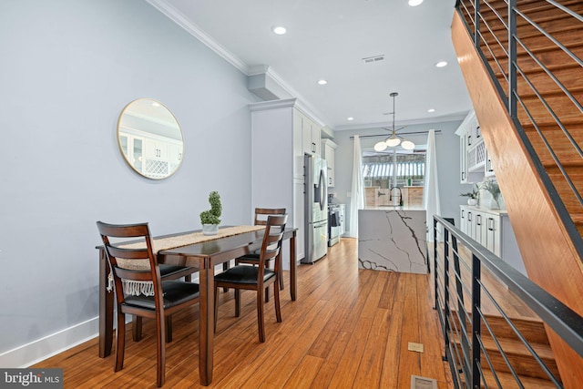 dining space featuring light hardwood / wood-style floors and ornamental molding