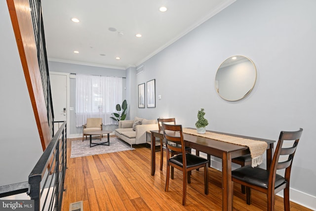 dining area featuring ornamental molding and light wood-type flooring