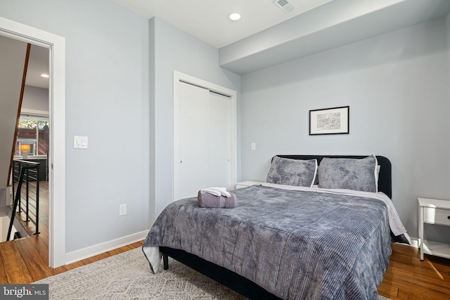 bedroom with a closet and hardwood / wood-style floors