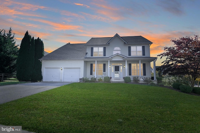 view of front facade featuring a lawn, a porch, and a garage