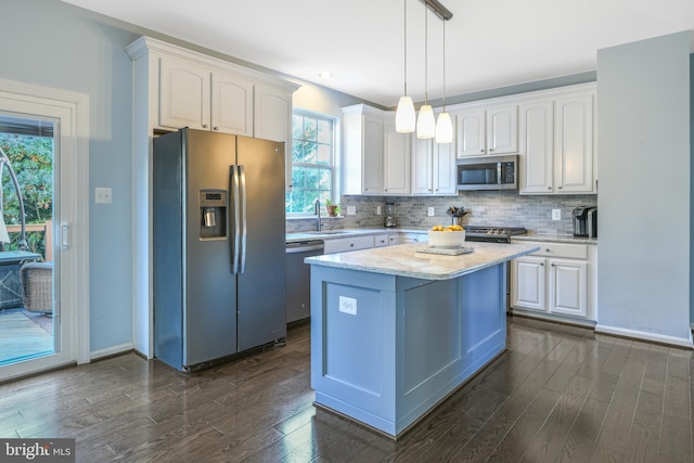 kitchen featuring white cabinetry, dark hardwood / wood-style flooring, stainless steel appliances, and decorative light fixtures