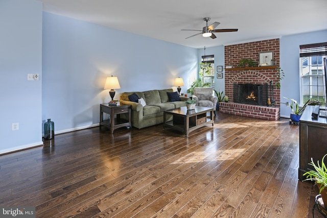 living room with ceiling fan, dark hardwood / wood-style flooring, and a brick fireplace