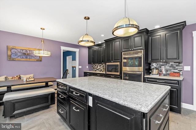 kitchen featuring a center island, tasteful backsplash, decorative light fixtures, and stainless steel appliances