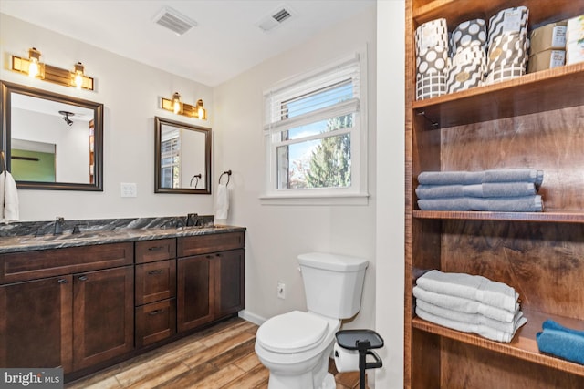 bathroom with vanity, hardwood / wood-style flooring, and toilet