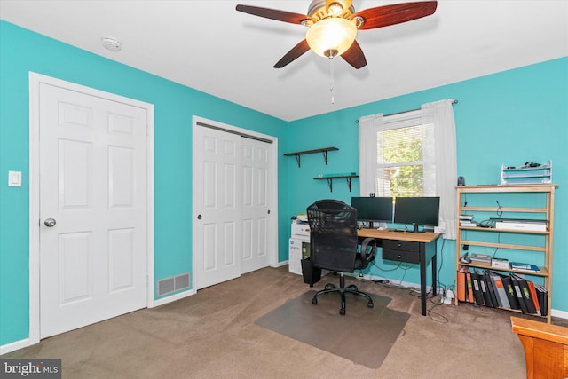 carpeted home office featuring ceiling fan