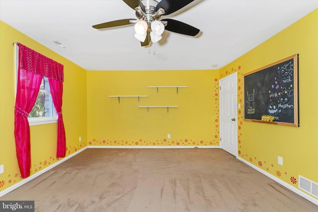 carpeted spare room featuring ceiling fan