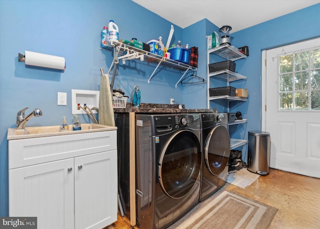 laundry area featuring cabinets, independent washer and dryer, and sink