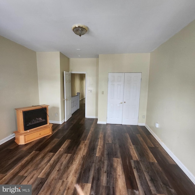 unfurnished bedroom with dark hardwood / wood-style floors and a closet