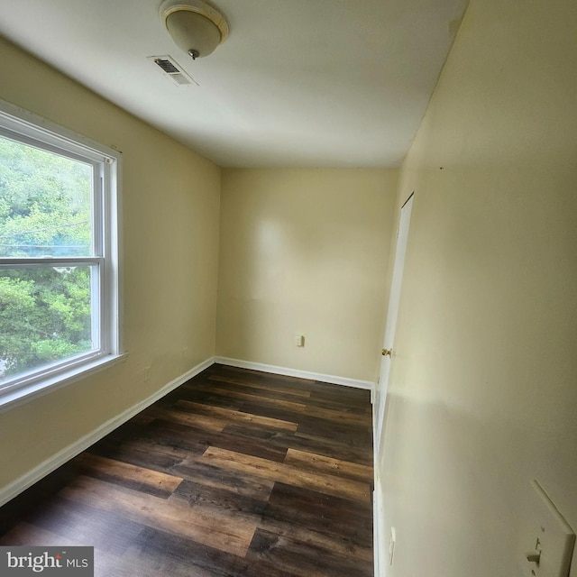 unfurnished room with a wealth of natural light and dark hardwood / wood-style flooring