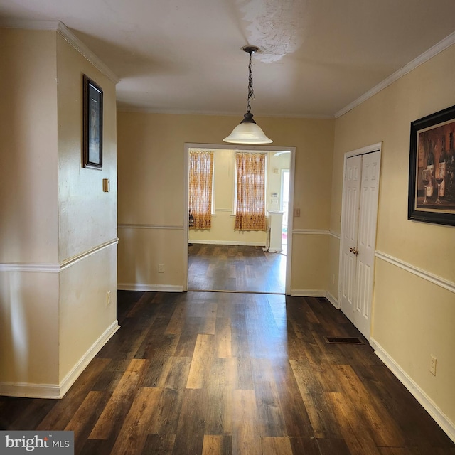 unfurnished dining area with ornamental molding and dark hardwood / wood-style flooring