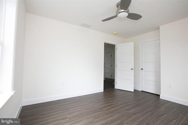 spare room featuring ceiling fan and dark hardwood / wood-style floors