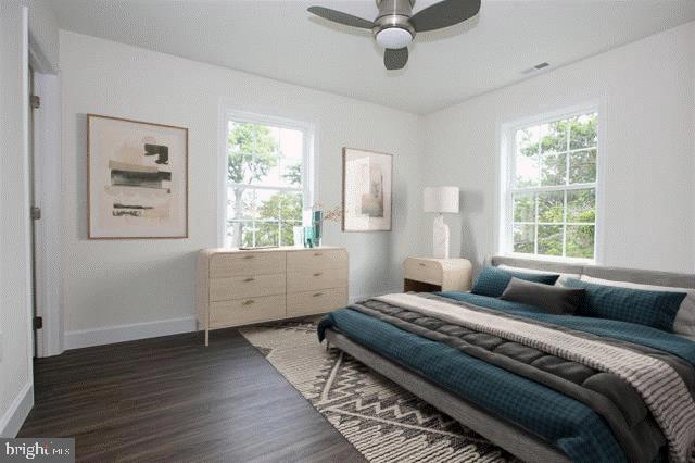 bedroom featuring dark wood-type flooring, multiple windows, and ceiling fan