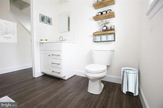 bathroom with vanity, hardwood / wood-style flooring, and toilet