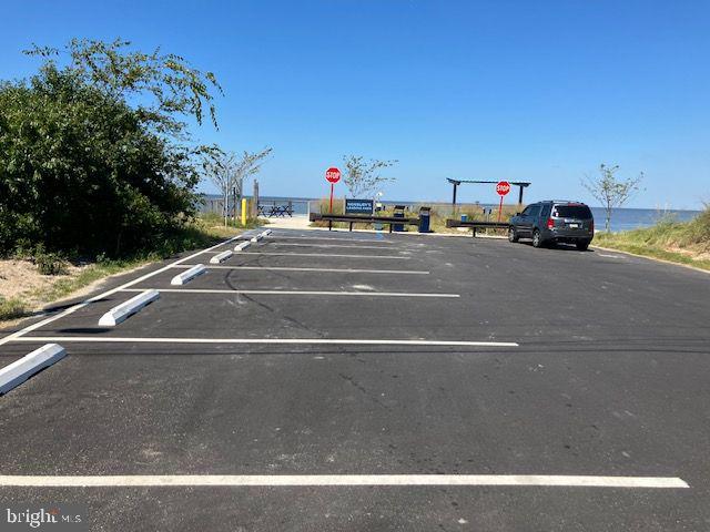 view of car parking featuring a water view